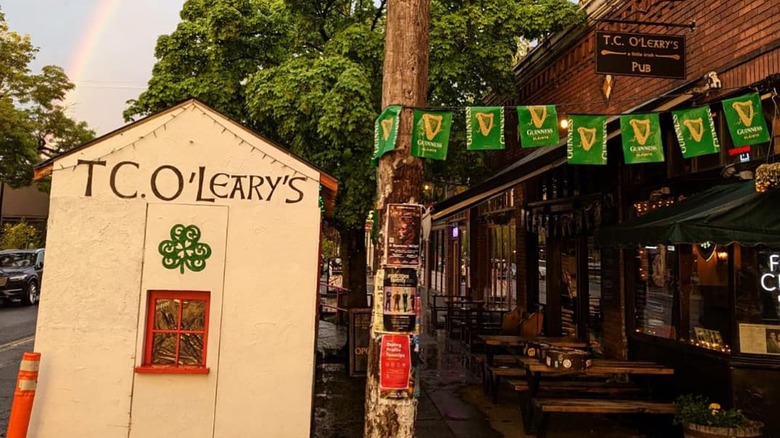 Exterior of TC O'Leary's with penants, and rainbow in the sky