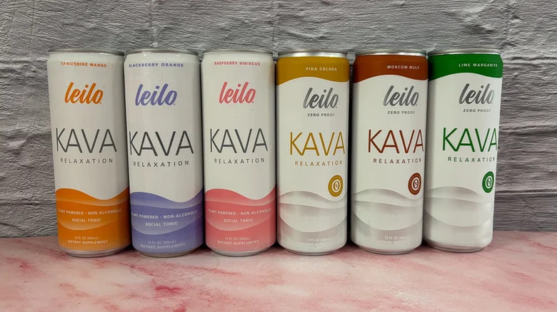 Six Leilo cans in a row against a wall