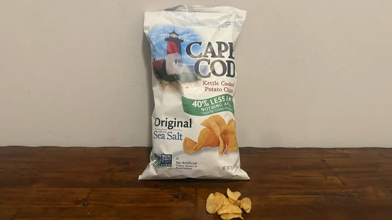 Kettle chips with bag on wooden table