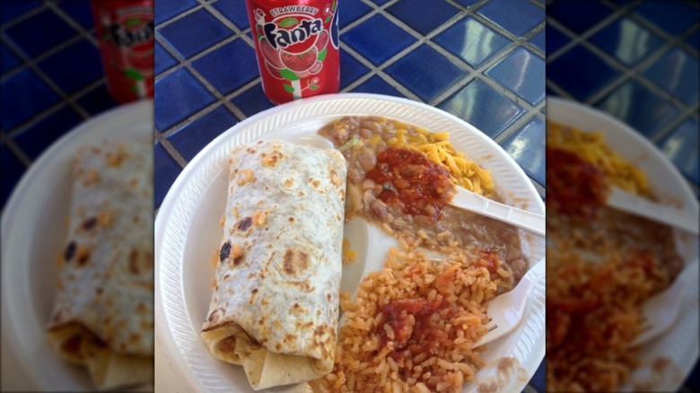 Plate with burritos, rice, beans, and a can of Fanta