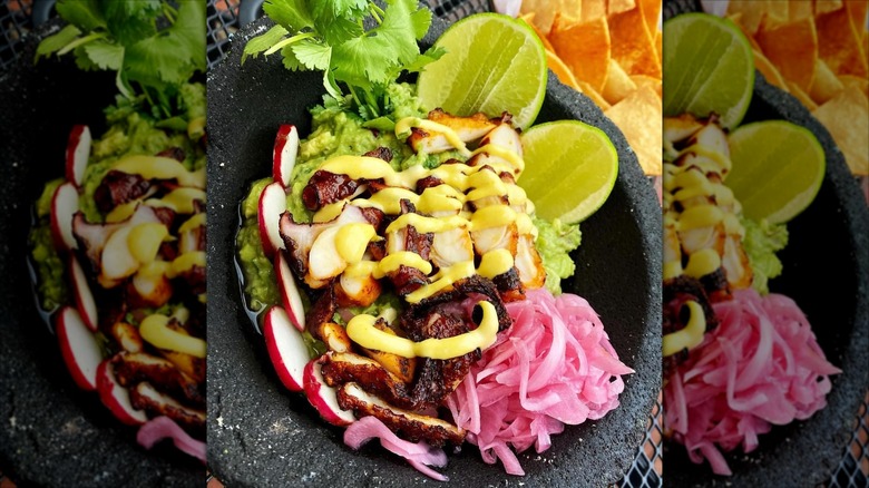 Mexican dish with fresh guacamole, pickled veg, limes, and cilantro