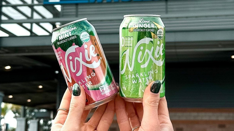person holding up two Nixie sparkling water options