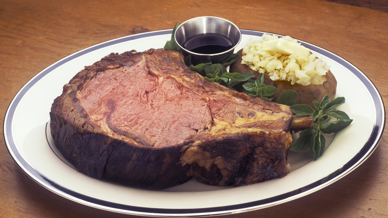 Prime rib on a plate with a stuffed potato