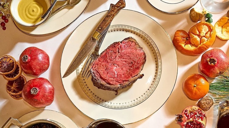 Prime rib on a plate surrounded by food