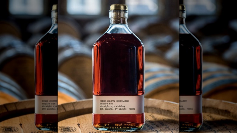 A bottle of Kings County Distillery Straight Empire Rye on a barrel