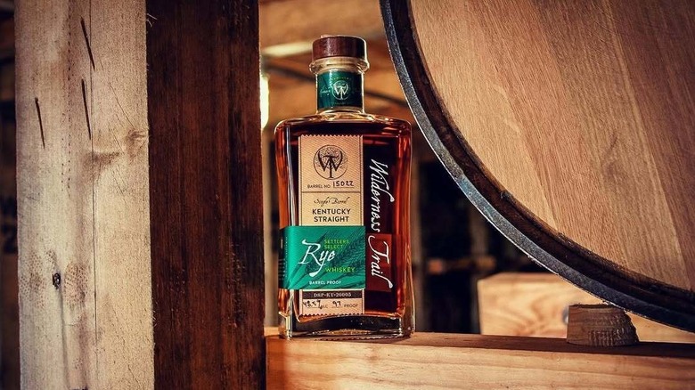 Bottle of Wilderness Trail Rye next to a barrel