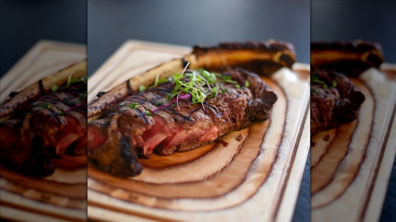 Black Angus Steakhouse's bone-in ribeye on wooden board