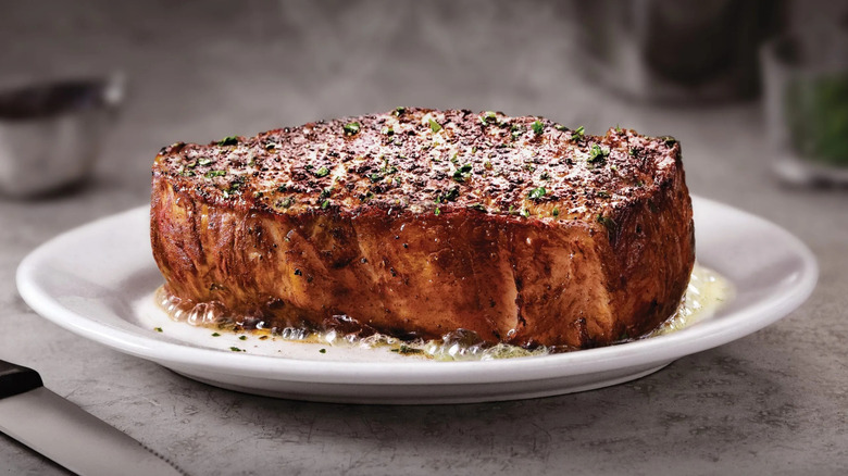 Ruth's Chris Steak House New York strip on white plate with bubbling butter