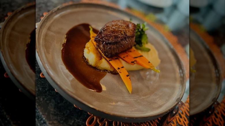 Filet on plate with mash, carrots, and sauce