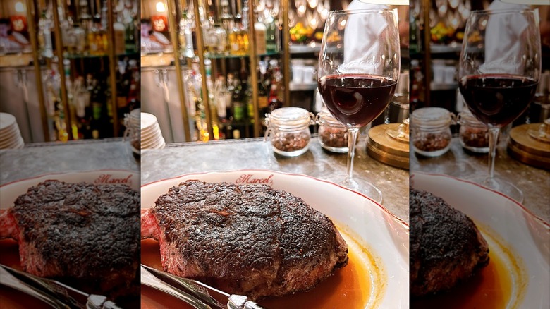 Juicy steak on a plate with glass of red wine