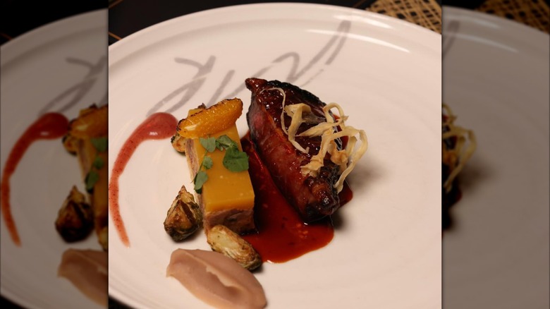White plate with fancy-looking steak and tiny sides