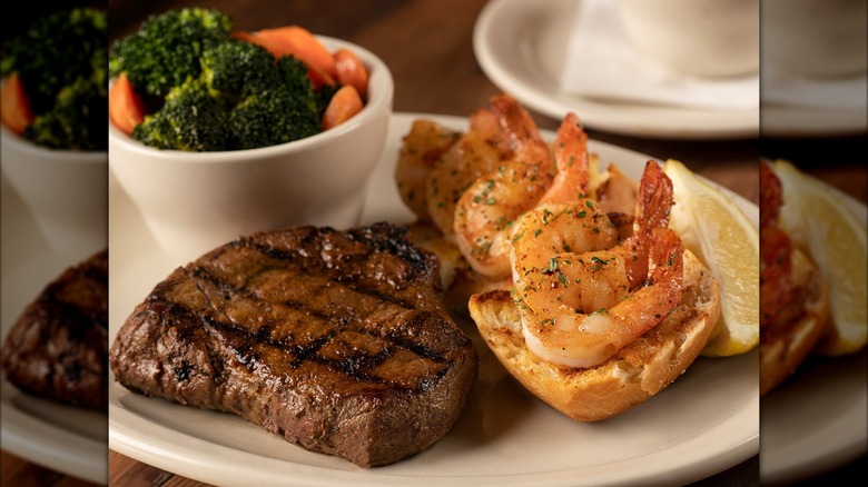 Sirloin on plate with shrimp, lemon, and side of vegetables