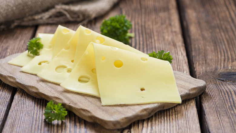 slices of Swiss cheese on wood platter