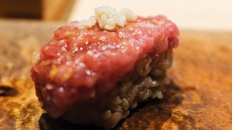 Single nigiri on a wooden platter