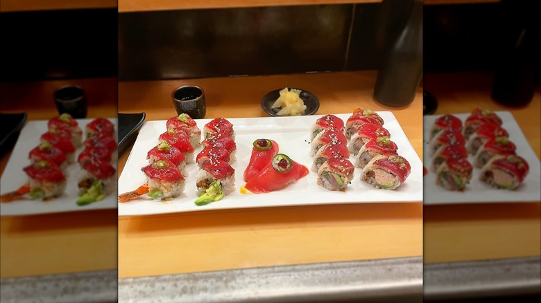 Nigiri and uramaki rolls topped with salmon, jalapeno, and sesame seeds