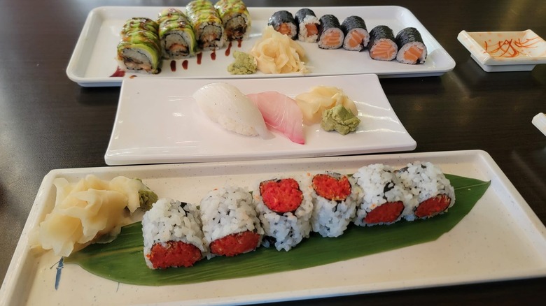 Spread of sushi rolls, uramaki rolls, and sashimi