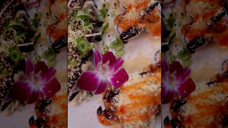 Sushi rolls topped with tempura flakes and sweet chili sauce