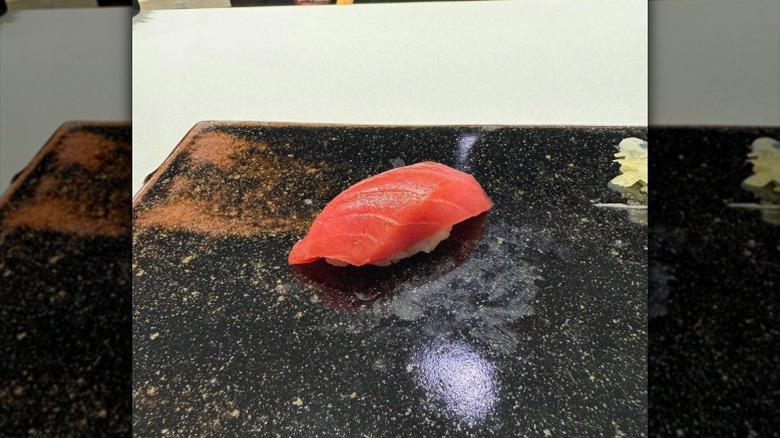 Salmon nigiri on a black plate