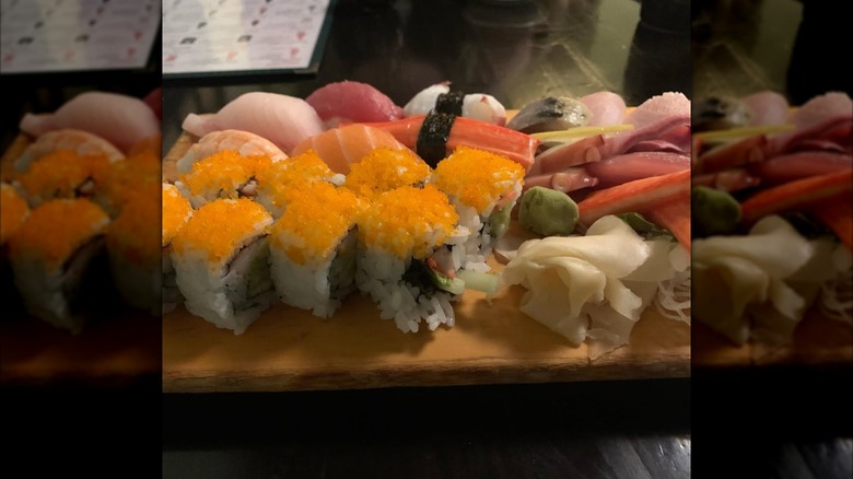 Wooden board with uramaki topped with caviar and nigiri