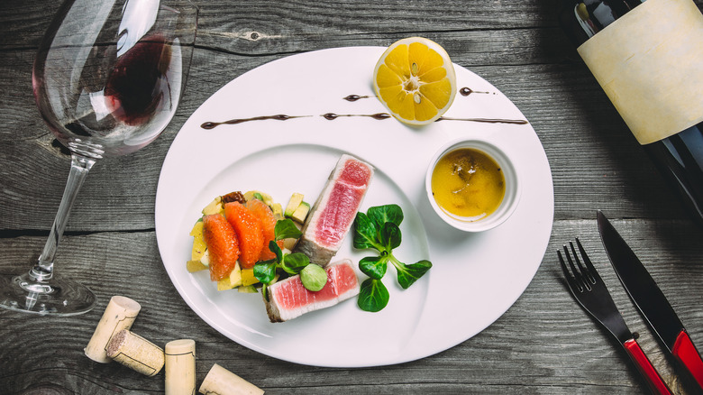 wine in glass with tuna on plate