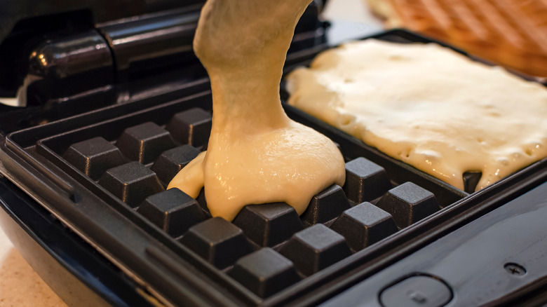 Pouring batter into waffle maker