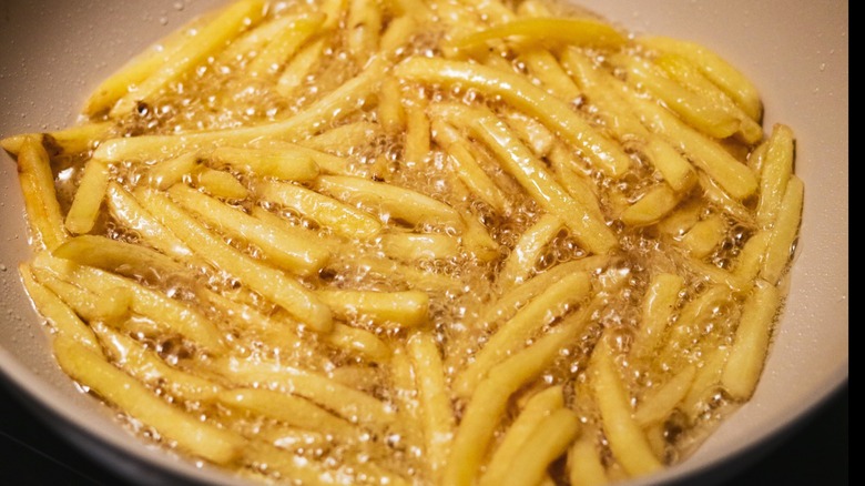 French fries in a pan of bubbling oil