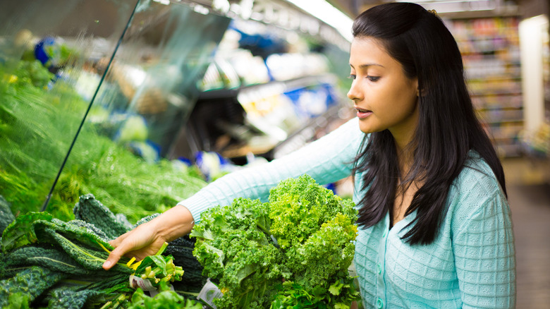 woman getting kale at supermarket