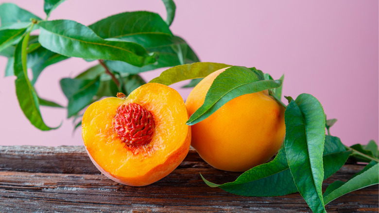 Halved peaches with peach leaves