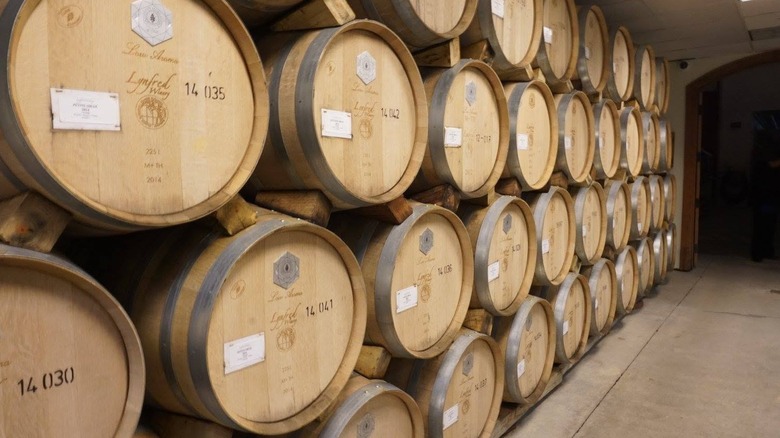 Four rows of stacked wine barrels with Lynfred Winery branding in a wine cellar.