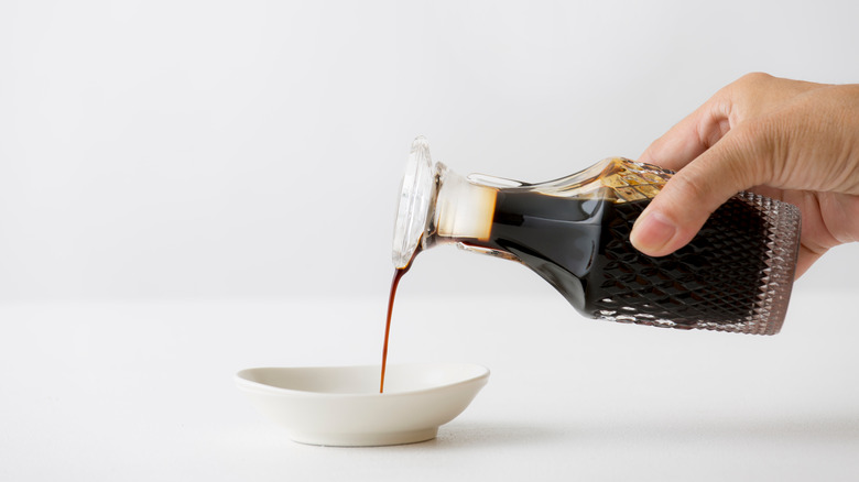 Pouring Worcestershire sauce from a glass bottle