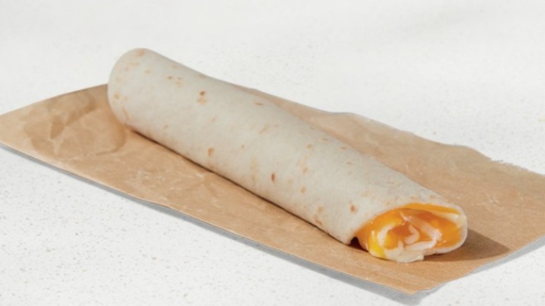 A Cheesy Roll-Up from Taco Bell resting on a brown wrapper