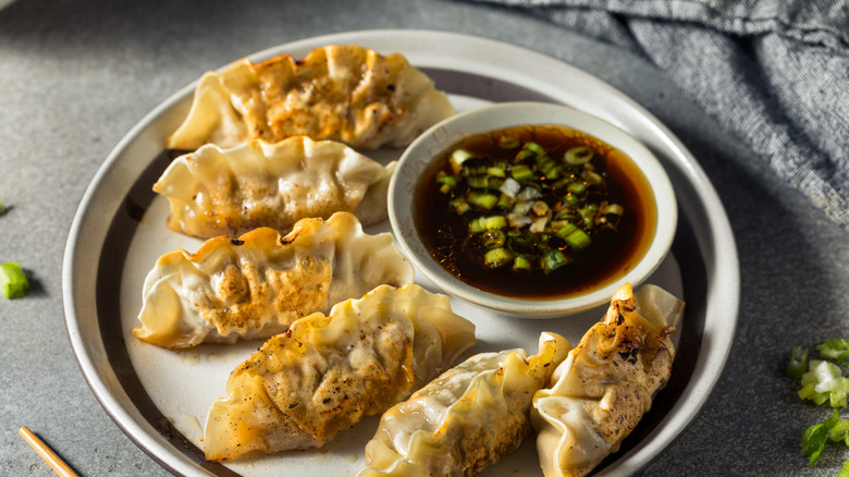 potstickers plated with dipping sauce
