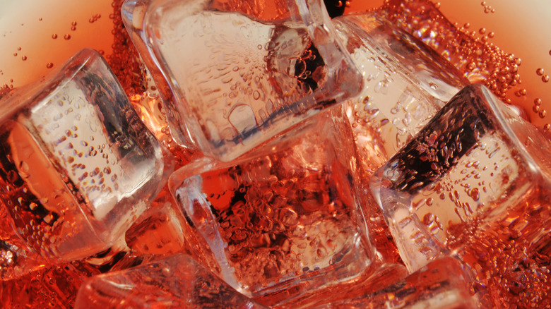Close-up of ice cubes in red soda