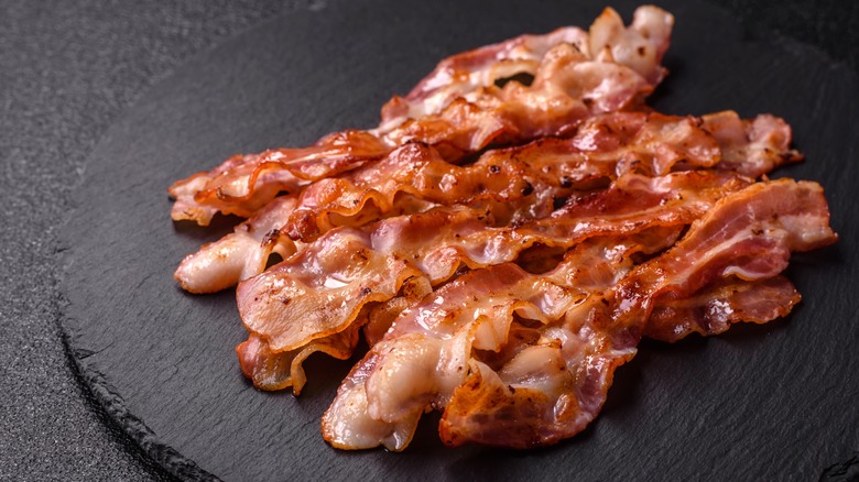 A black slab of crispy bacon slices