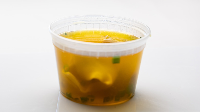 A takeout container full of soup