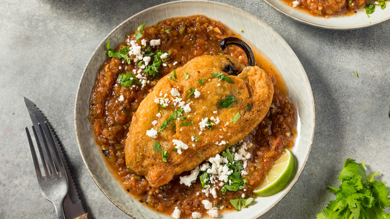 homemade fried chile relleno over red salsa