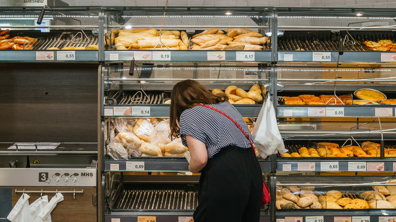 person chooses baked goods from an Aldi bakery display