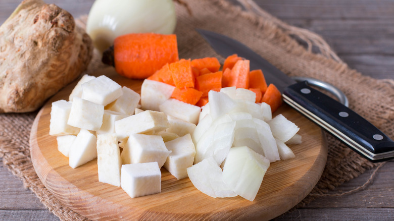 Chopped carrots and turnips on wooden cutting board