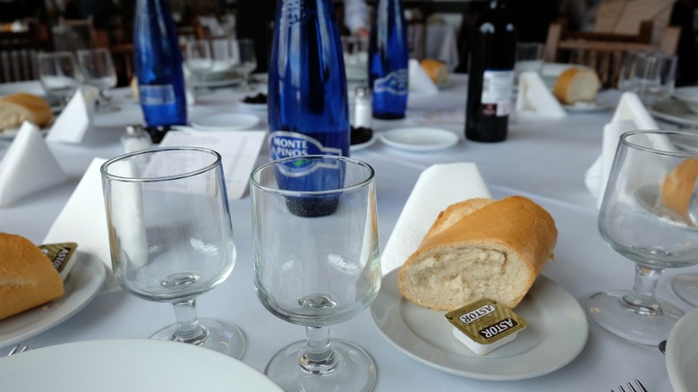 A set table with complimentary bread and butter alongside each table setting