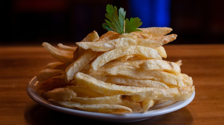 White plate of garnished french fries
