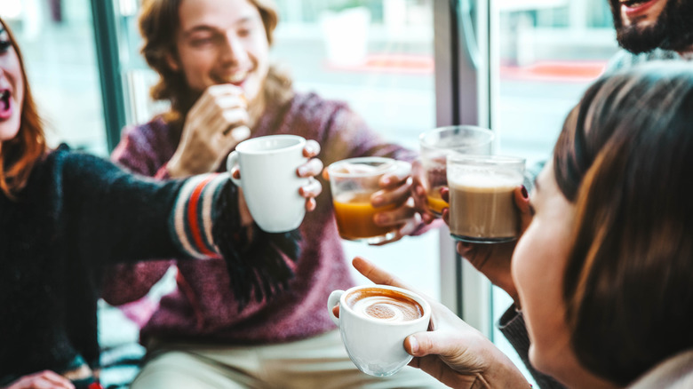 Group of friends toasting mugs of winter drinks