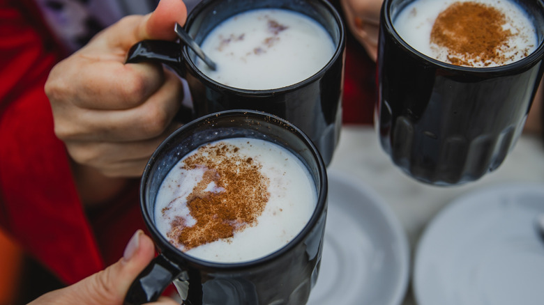 Close-up of people holding cups of sachlav
