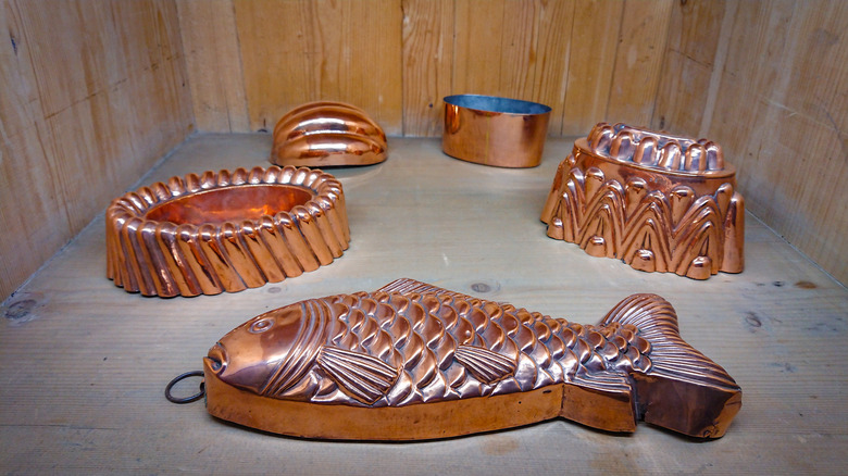 A set of copper molds for baking, including a copper fish mold
