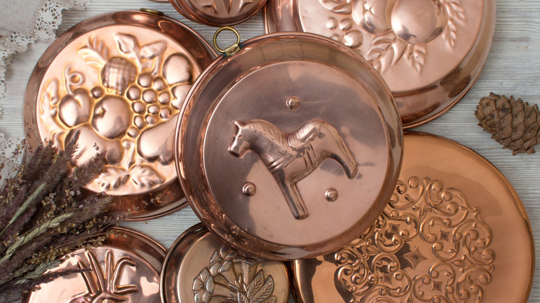 An array of copper baking molds on a table
