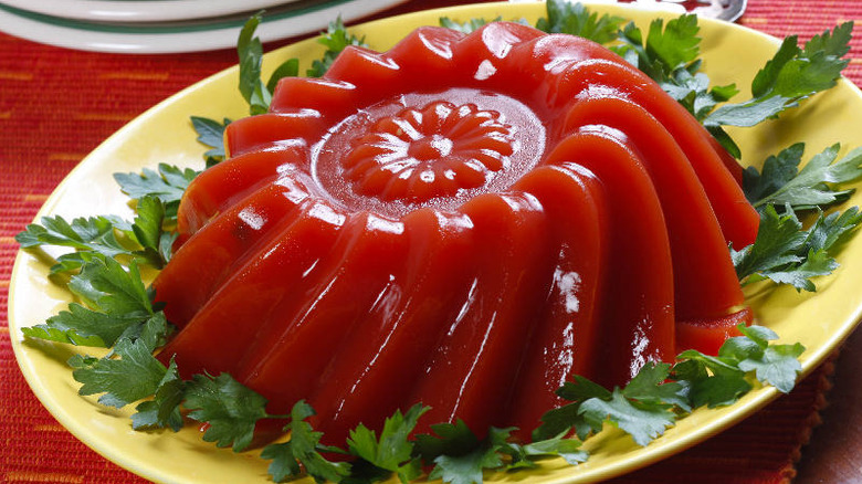 Tomato aspic jello mold surrounded by celery leaves