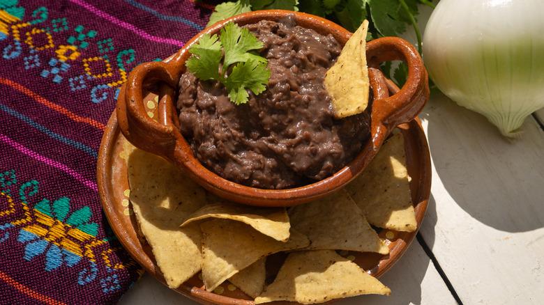 refried black beans in earthenware dish