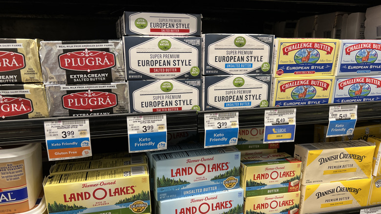 Various brands of butter on the aisle of a supermarket.