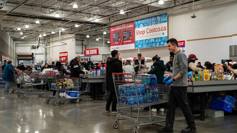 Costco customers with loaded carts at checkout