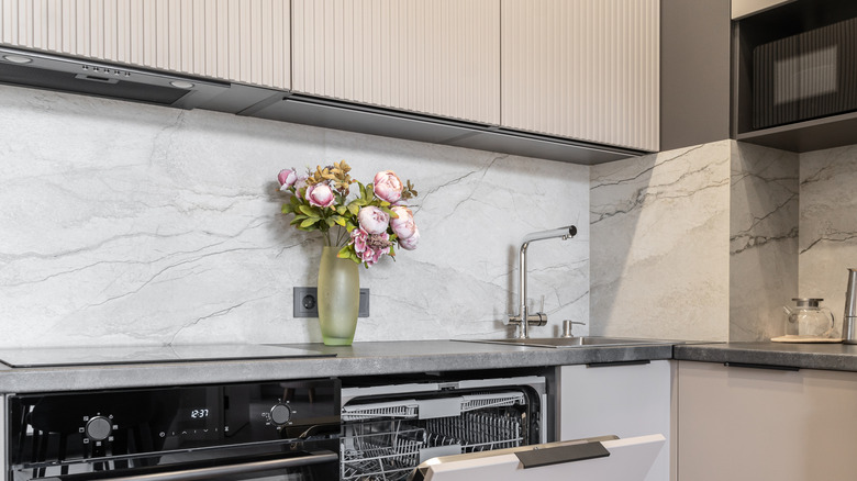 A kitchen with a neutral, marble backsplash