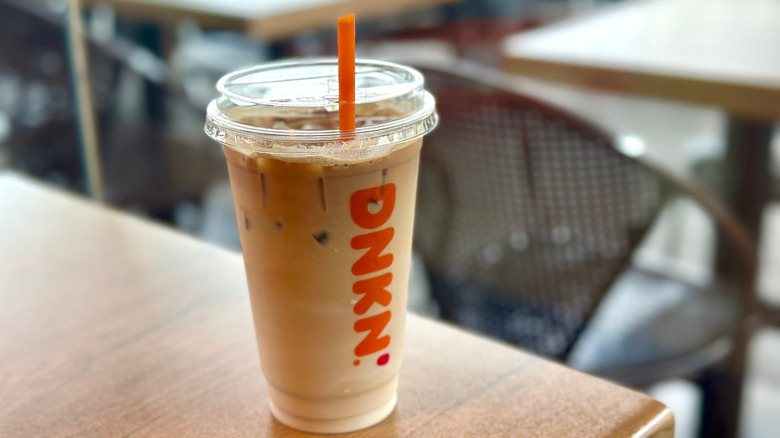 Iced Dunkin' latte on wooden surface